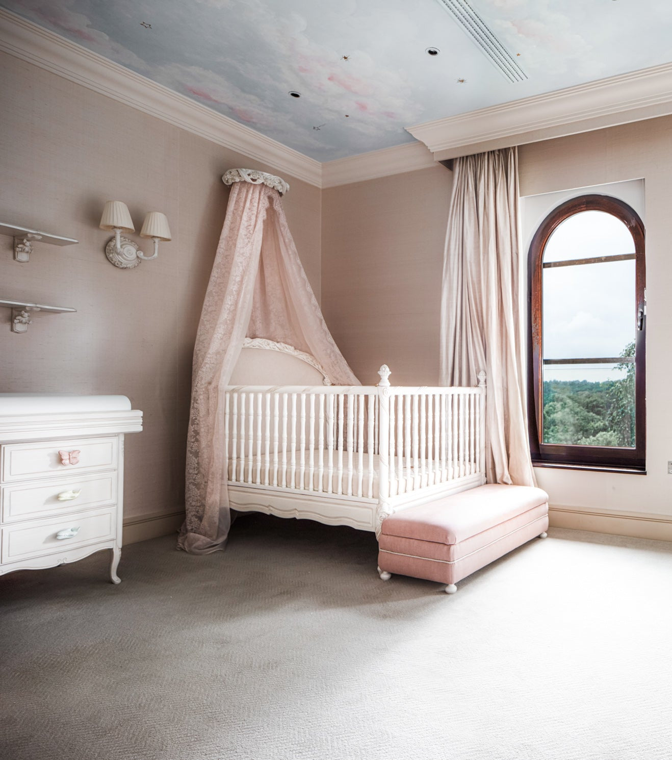 Luxurious nursery with white crib, canopy, and pink accents.